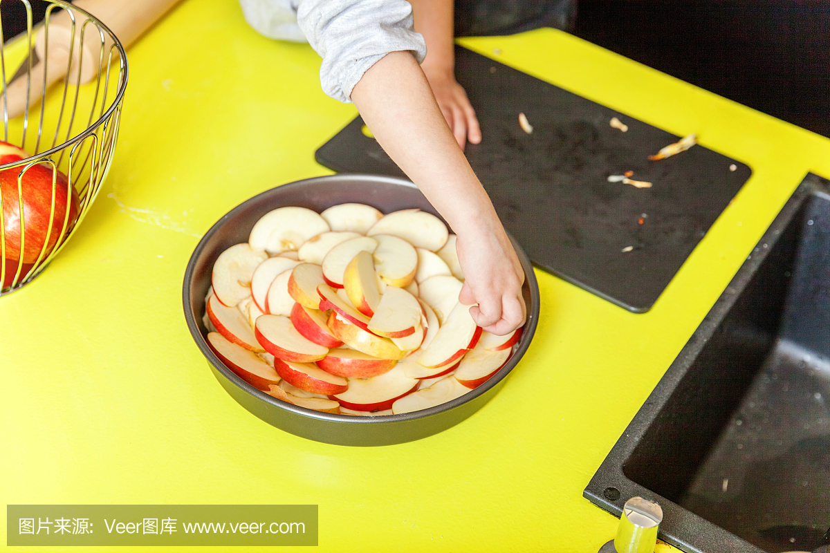 小女孩在廚房準(zhǔn)備自制的節(jié)日蘋(píng)果派